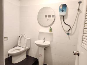 a bathroom with a toilet and a sink and a mirror at Jellyfish Hostel in Jomtien Beach +36 photos