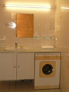 a bathroom with a sink and a washing machine at Appartement Centre Ville Tours in Tours