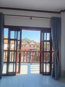 an open glass door with a view of a balcony at Villa ThreeD Xaydara in Luang Prabang