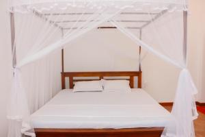 a bed with a canopy in a room at Anula Villa in Ahangama