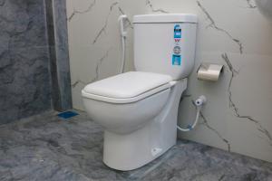 a bathroom with a white toilet in a room at Anula Villa in Ahangama
