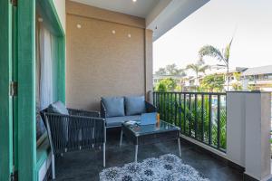 a balcony with a couch and a glass table at Trideus The Wild Fraser Corbett in Rāmnagar