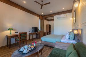 a bedroom with a bed and a living room at Trideus The Wild Fraser Corbett in Rāmnagar