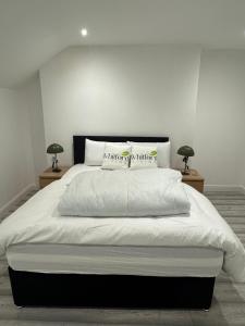 a bedroom with a large white bed with two lamps at Whitford living 2 in Jarrow