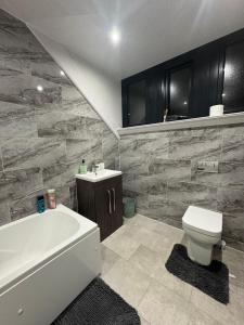 a bathroom with a tub and a toilet and a sink at Whitford living 2 in Jarrow