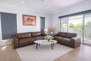 a living room with a couch and a table at 4BR Family Home w Golf Course Views, BBQ & Secure Parking in Rosslea