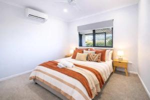 a white bedroom with a large bed and a window at 4BR Family Home w Golf Course Views, BBQ & Secure Parking in Rosslea