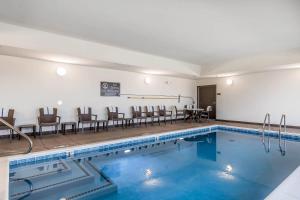a pool with chairs and a table in a room at Sleep Inn & Suites O'Fallon MO - Technology Drive in O'Fallon
