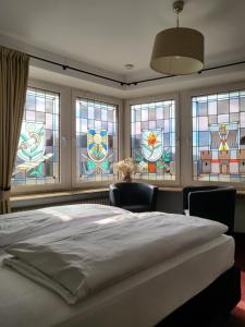 a bedroom with stained glass windows and a bed at Hotel Rüdesheimer Hof in Rüdesheim am Rhein +28 photos