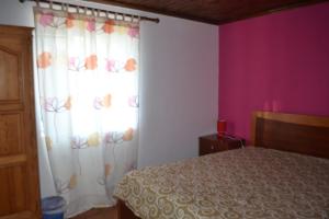1 dormitorio con cama y cortina blanca con mariposas en TINA 3B - Alojamento Local - RRAL 760, en Porto Martins