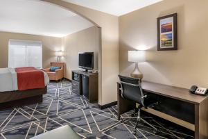 a hotel room with a bed and a desk with a television at Comfort Inn & Suites Lubbock West in Lubbock