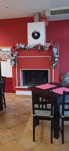 a dining room with a red wall with a fireplace at Bed & Breakfast Valeri in Artena