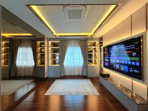 a living room with a tv and a flat screen tv at Luxury house for rent near Suvarnabhumi Airport in Sathani Lat Krabang