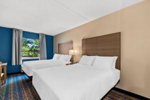 a hotel room with two beds and a window at Quality Inn & Suites Shepherdstown in Shepherdstown