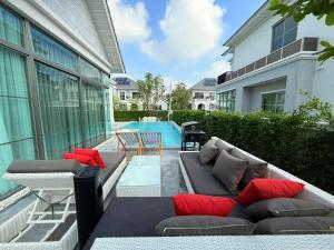 a patio with a couch and chairs and a pool at Luxury house for rent near Suvarnabhumi Airport in Sathani Lat Krabang