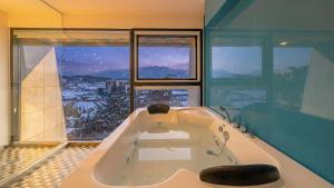 a bath tub in a bathroom with a large window at goseong theprism pension in Goseong +9 photos