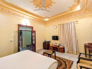 a bedroom with a king sized bed and a couch at Syna Heritage Hotel in Khajurāho
