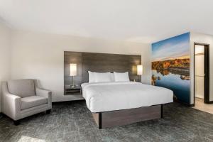 a hotel room with a bed and a chair at Clarion Pointe Prescott Valley in Prescott Valley +24 photos