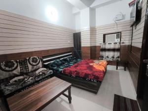 a room with two beds and a couch in it at Arjun House Hotel- Guest House in Pathānkot