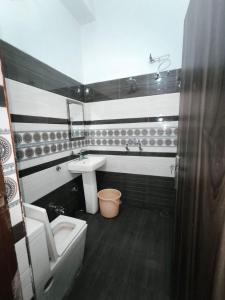 a bathroom with a sink and a tub and a toilet at Arjun House Hotel- Guest House in Pathānkot +14 photos