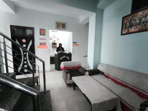 a room with a couch and a person standing in a room at Arjun House Hotel- Guest House in Pathānkot
