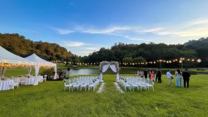a wedding ceremony with white chairs and a arch at Three Hills Resort & Spa, Coorg in Madikeri +275 photos