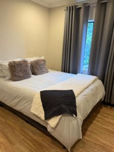 a large bed in a room with a window at Avo 2 on 27 Drew in Howick
