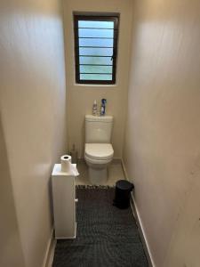 a small bathroom with a toilet and a window at Avo 2 on 27 Drew in Howick