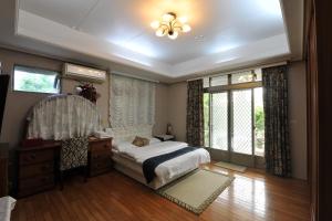 a bedroom with a bed and a dresser and windows at Yun Siang Ju Homestay in Jiaoxi +24 photos