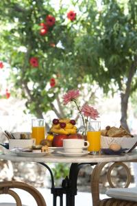 a table with food and orange juice on it at Doukissa Hotel - Parikia Town Centre in Parikia