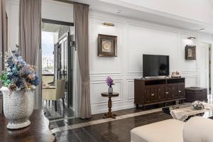 a living room with a television and a couch at Buri Sriping Riverside Resort & Spa in Chiang Mai