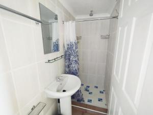 a white bathroom with a sink and a shower at Billy Bay Cottage in Margate +30 photos