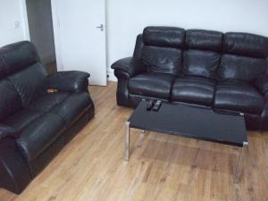 a black leather couch and a table in a living room at The Grange in Middlesbrough