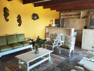 a living room with a couch and chairs and a table at Billy Bay Cottage in Margate