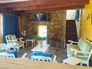 a living room with chairs and tables and a tv at Billy Bay Cottage in Margate