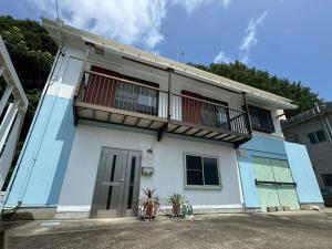 a blue and white house with a balcony at 海輪邸 in Shima