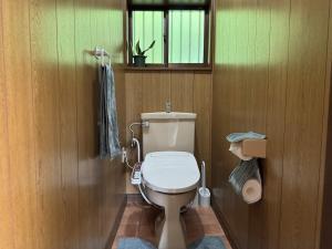 a bathroom with a toilet in a wooden wall at 海輪邸 in Shima +42 photos