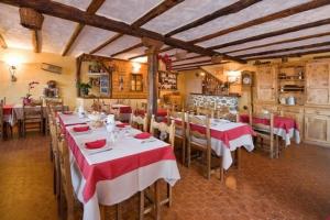 a restaurant with tables and chairs with red and white table cloth at Auberge du Rochasson in Risoul