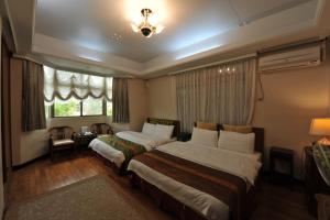 a hotel room with two beds and a window at Yun Siang Ju Homestay in Jiaoxi