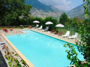 a large swimming pool with chairs and umbrellas at Auberge du Rochasson in Risoul