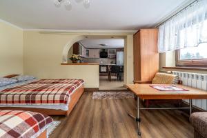 a bedroom with a bed and a table and a kitchen at Dom Na Borku Józefa Schulz in Ciche