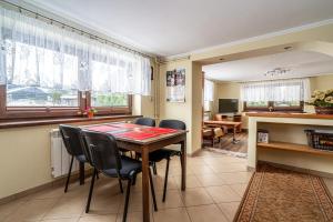 a kitchen and dining room with a table and chairs at Dom Na Borku Józefa Schulz in Ciche