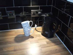 a coffee maker and a cup on a wooden floor at The Grange in Middlesbrough