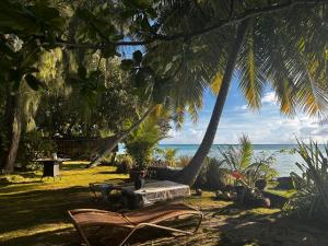 a table and chairs on the beach under palm trees at Kukuriaz Fare in Bora Bora