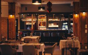 a restaurant with tables and chairs and a bar at Stara Owczarnia NOWA NIEDRZWICA in Nowa Niedrzwica +9 photos