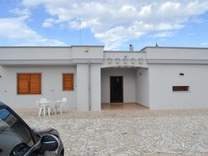 a white house with two chairs and a door at Villa Alaya in Manduria