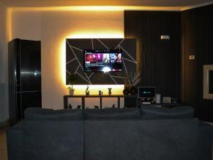 a living room with a blue couch and a flat screen tv at Villa Alaya in Manduria