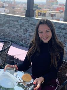 a woman sitting at a table with a plate of food at Hostal Mirador in Pisco
