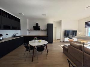 a kitchen and living room with a table and a couch at Exclusive penthouse with stunning panoramic views in Prijevor