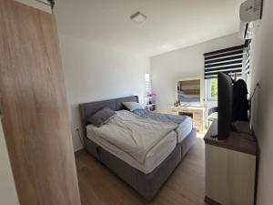 a bedroom with a bed and a flat screen tv at Exclusive penthouse with stunning panoramic views in Prijevor +24 photos